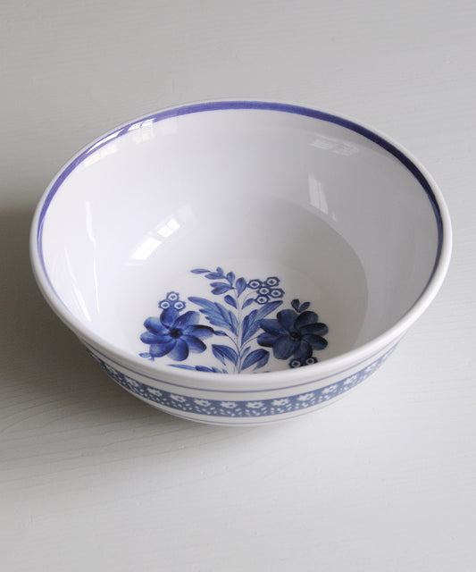 White melamine bowl with blue floral design on a white background