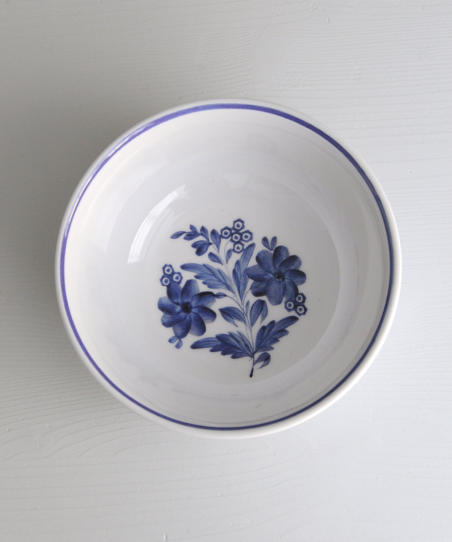 White melamine bowl with blue floral design on a gray background