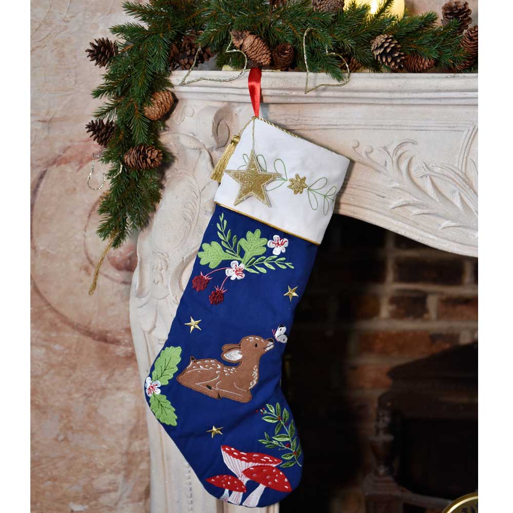 Decorative Christmas stocking with festive designs hanging on a fireplace mantle.