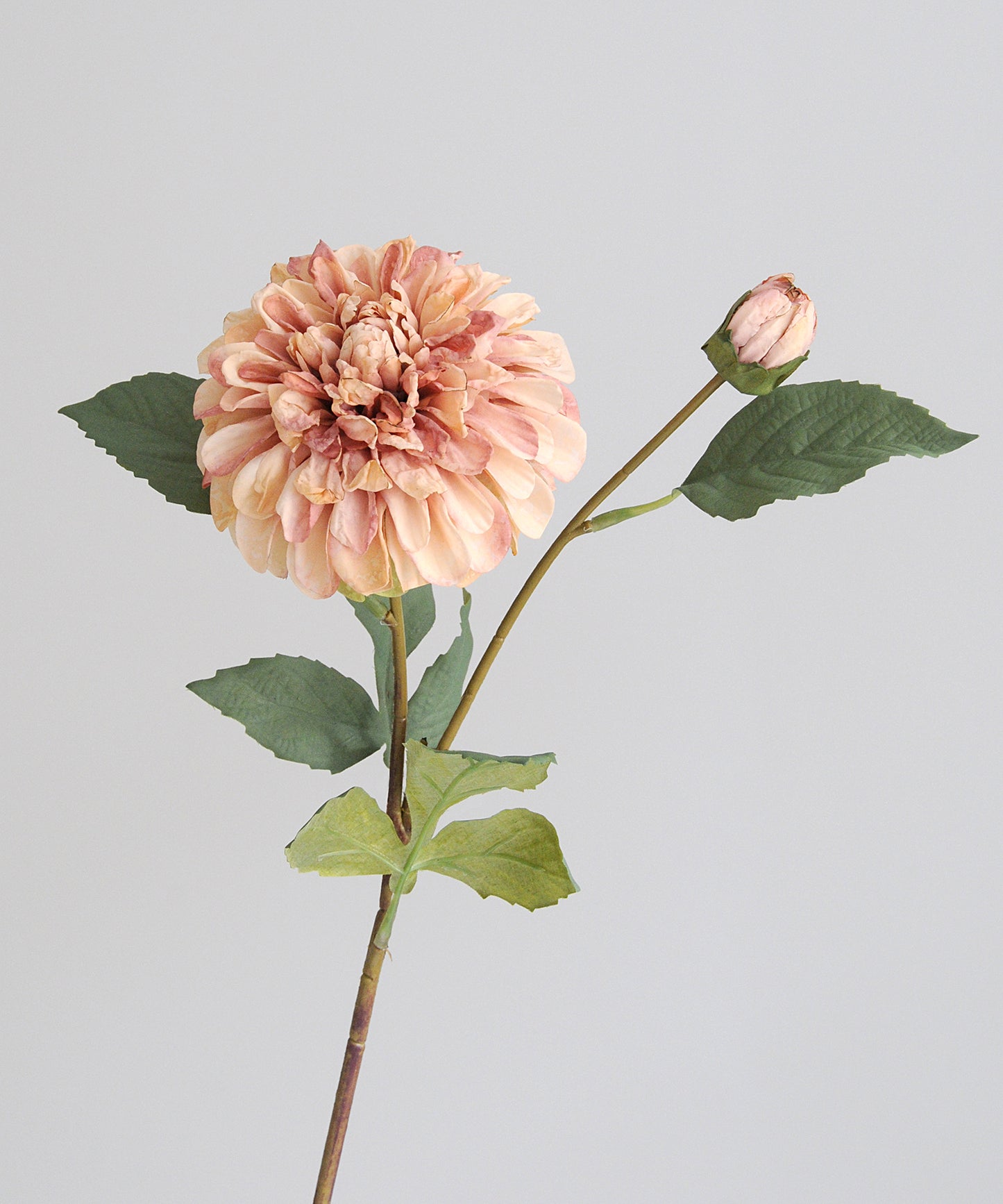 Artificial flower with a pink bloom and green leaves on a light gray background