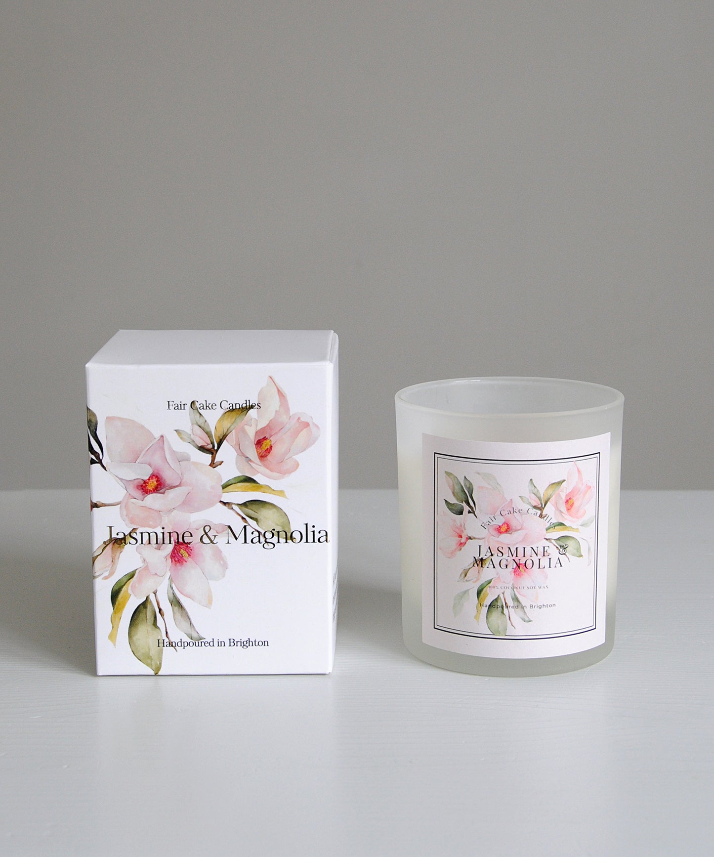 Fragranced candle and packaging with floral design on a gray background