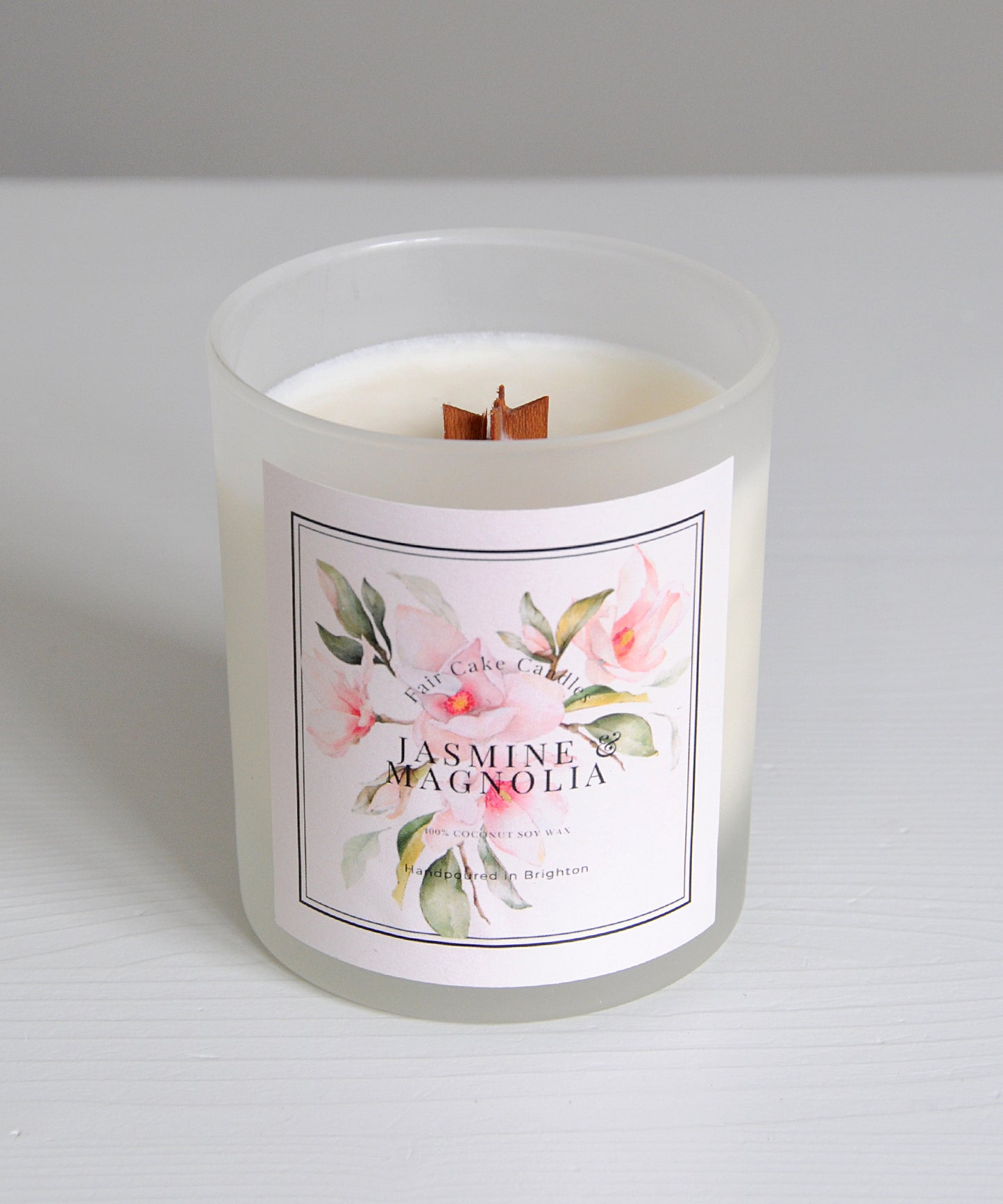 Candle with a floral label on a white background