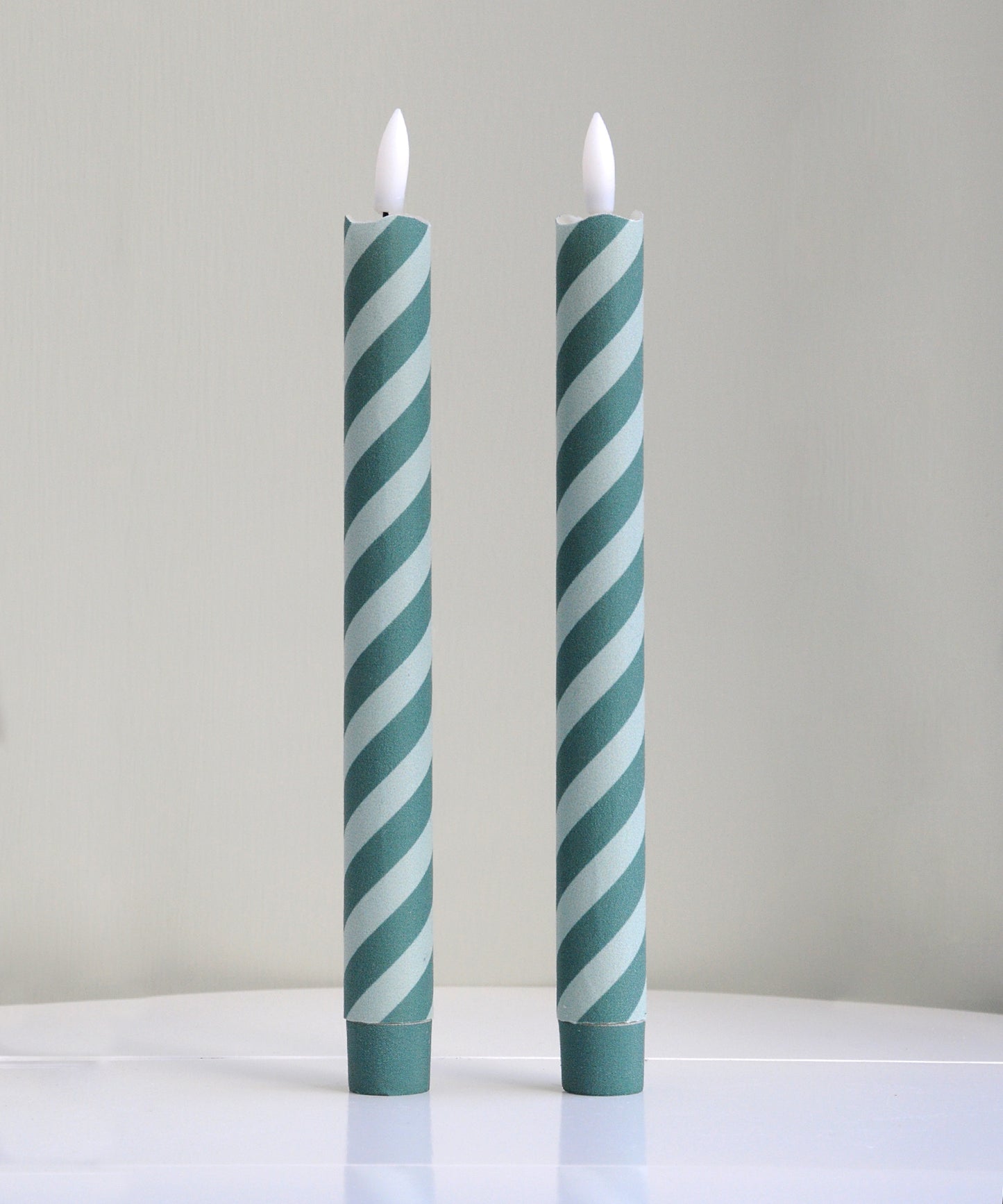 Two striped candles with green and white pattern