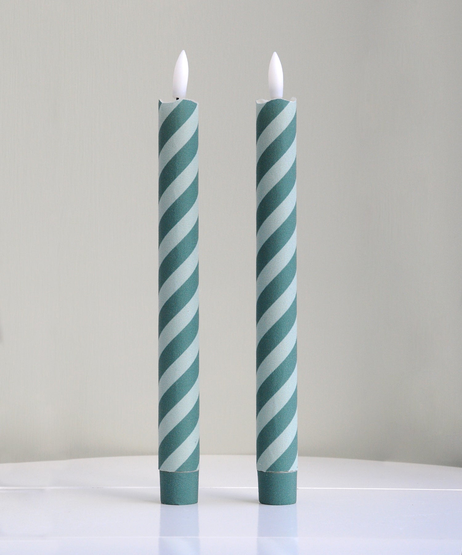 Two striped candles with green and white pattern