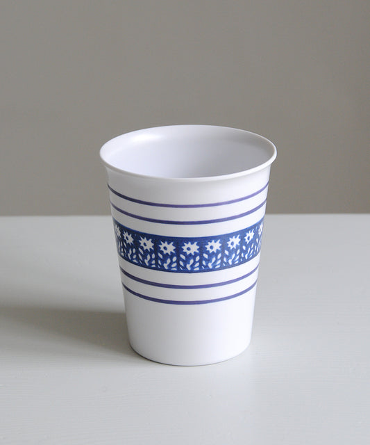 White cup with blue floral pattern on a gray background