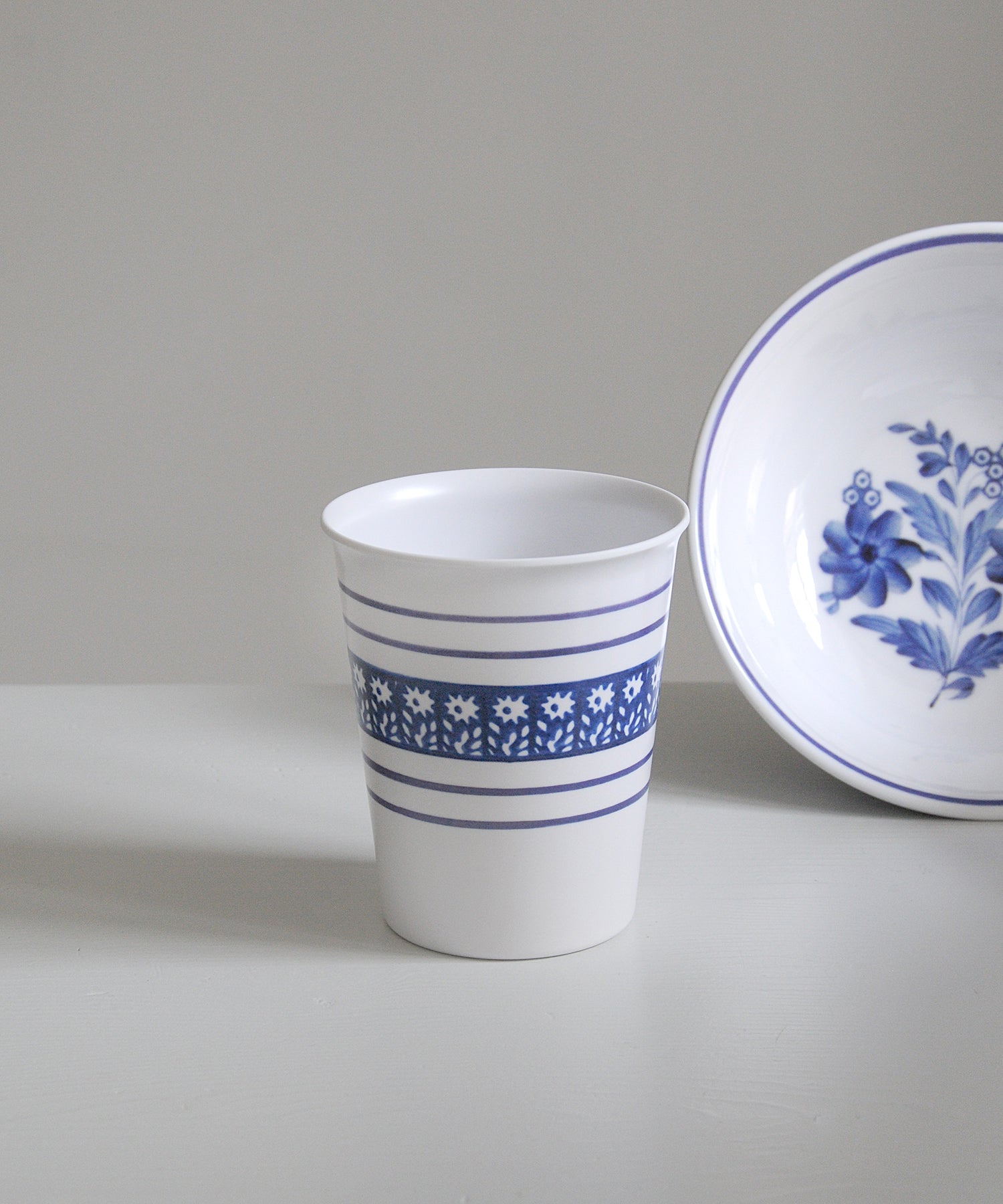 White cup with blue floral patterns on a gray background