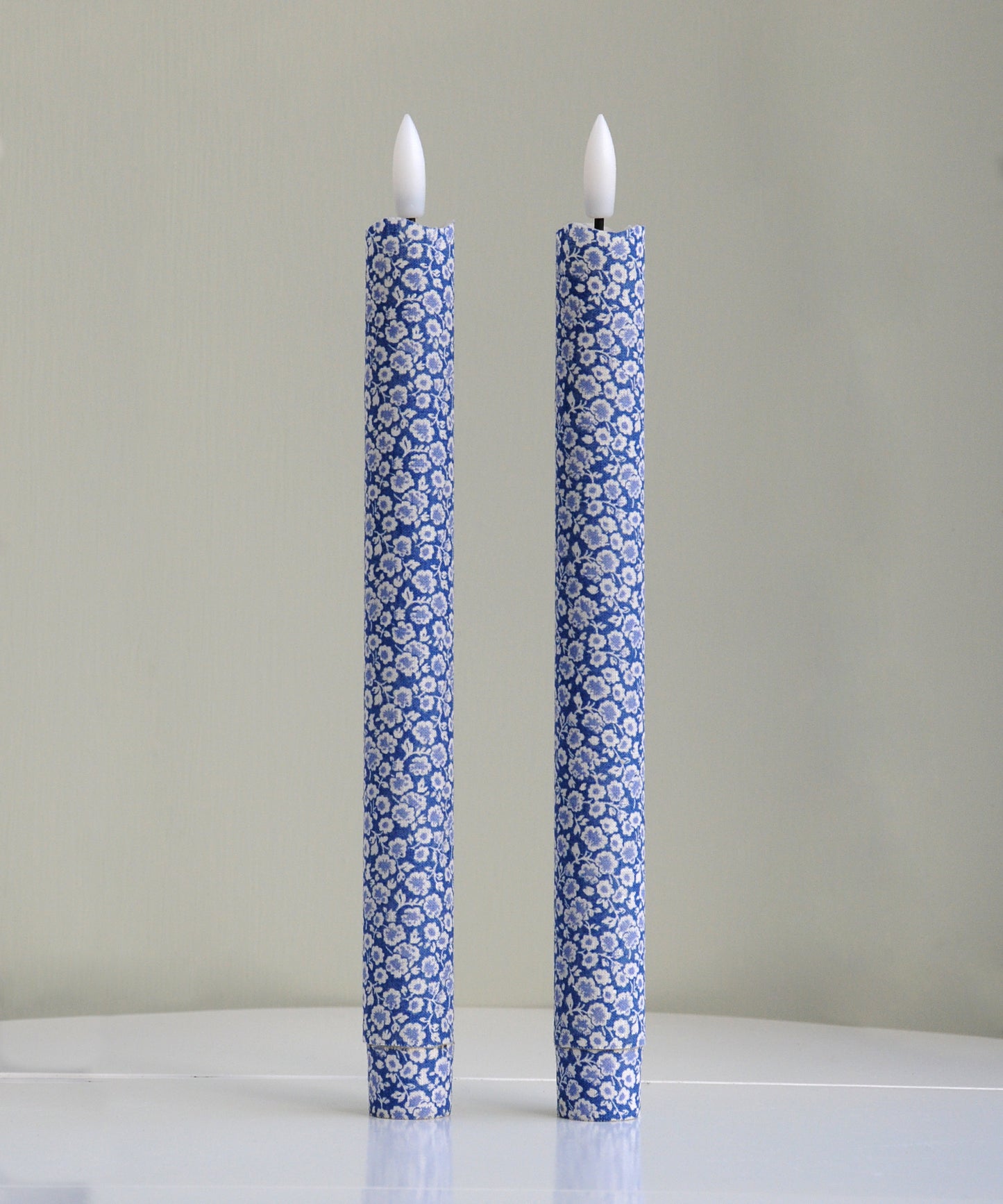 Two blue floral-patterned candles 