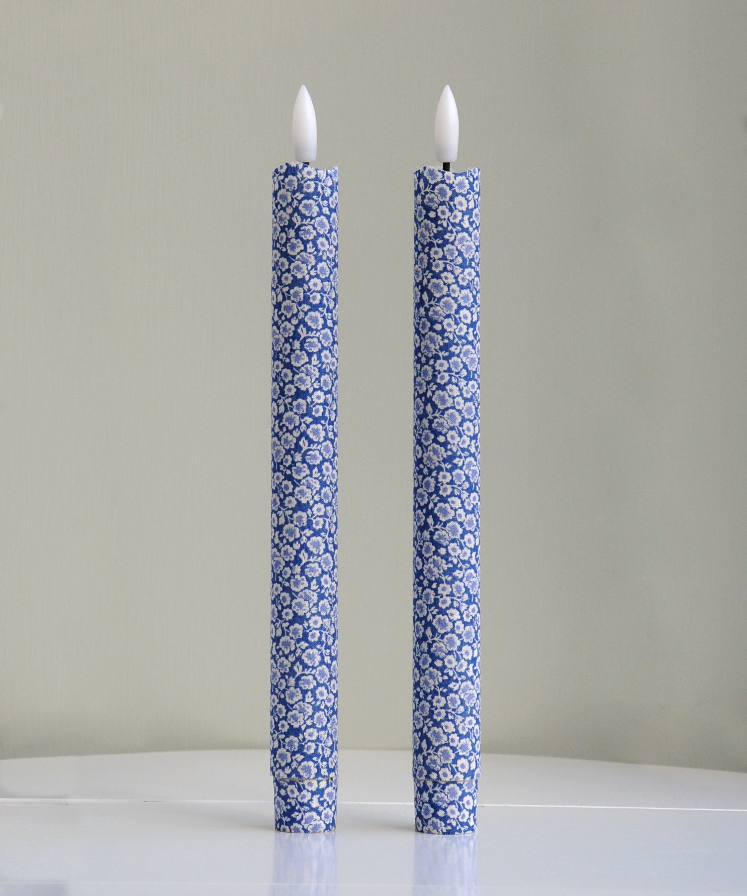 Two blue floral-patterned candles 